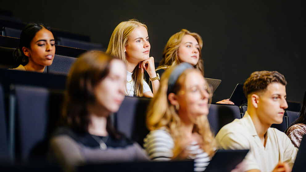 Junge Menschen sitzen zusammen in einem Hörsaal.