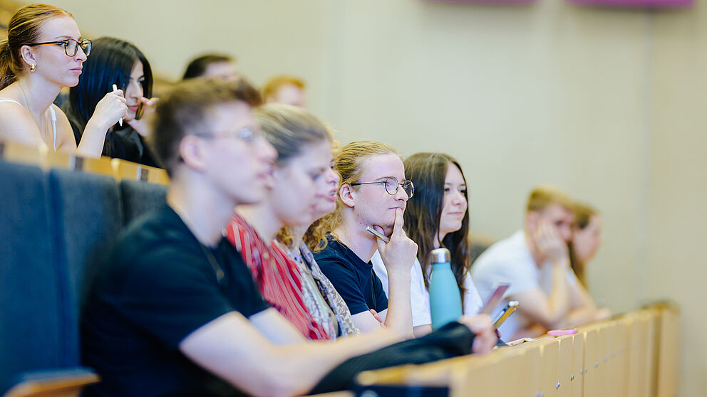 Junge Menschen sitzen zusammen in einem Hörsaal.