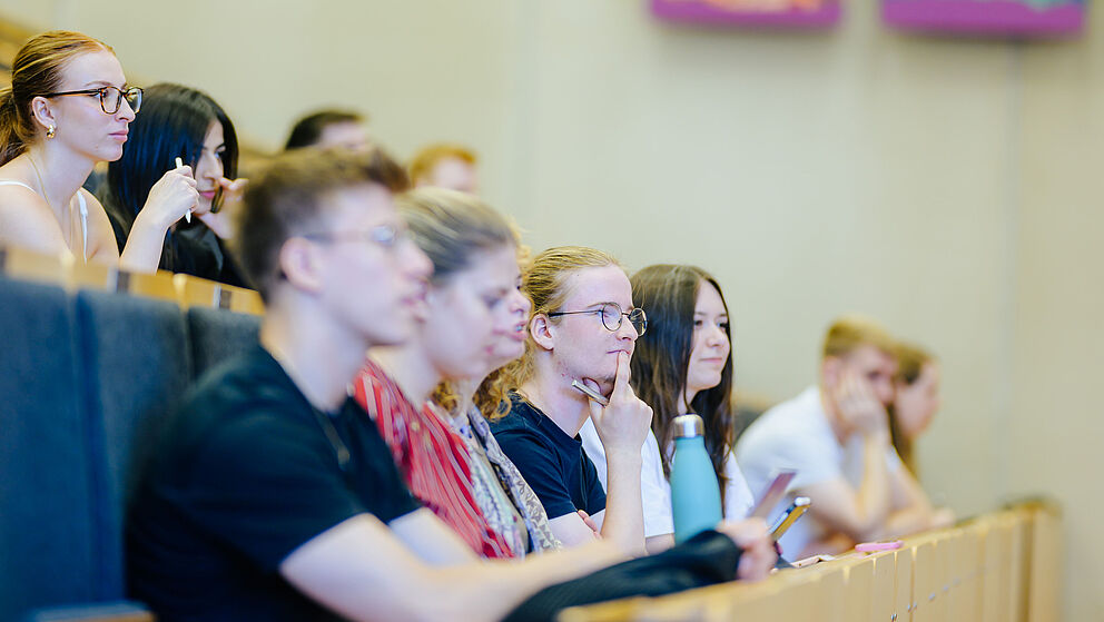 Junge Menschen sitzen zusammen in einem Hörsaal.