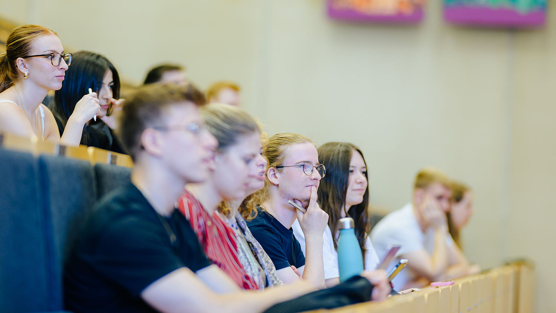 Junge Menschen sitzen zusammen in einem Hörsaal.