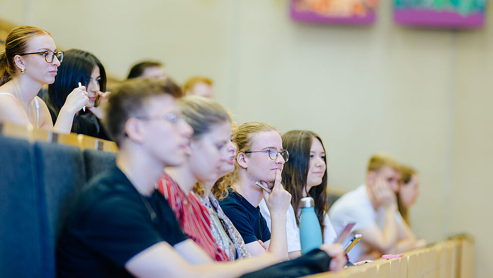 Junge Menschen sitzen zusammen in einem Hörsaal.