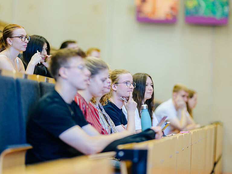 Junge Menschen sitzen zusammen in einem Hörsaal.