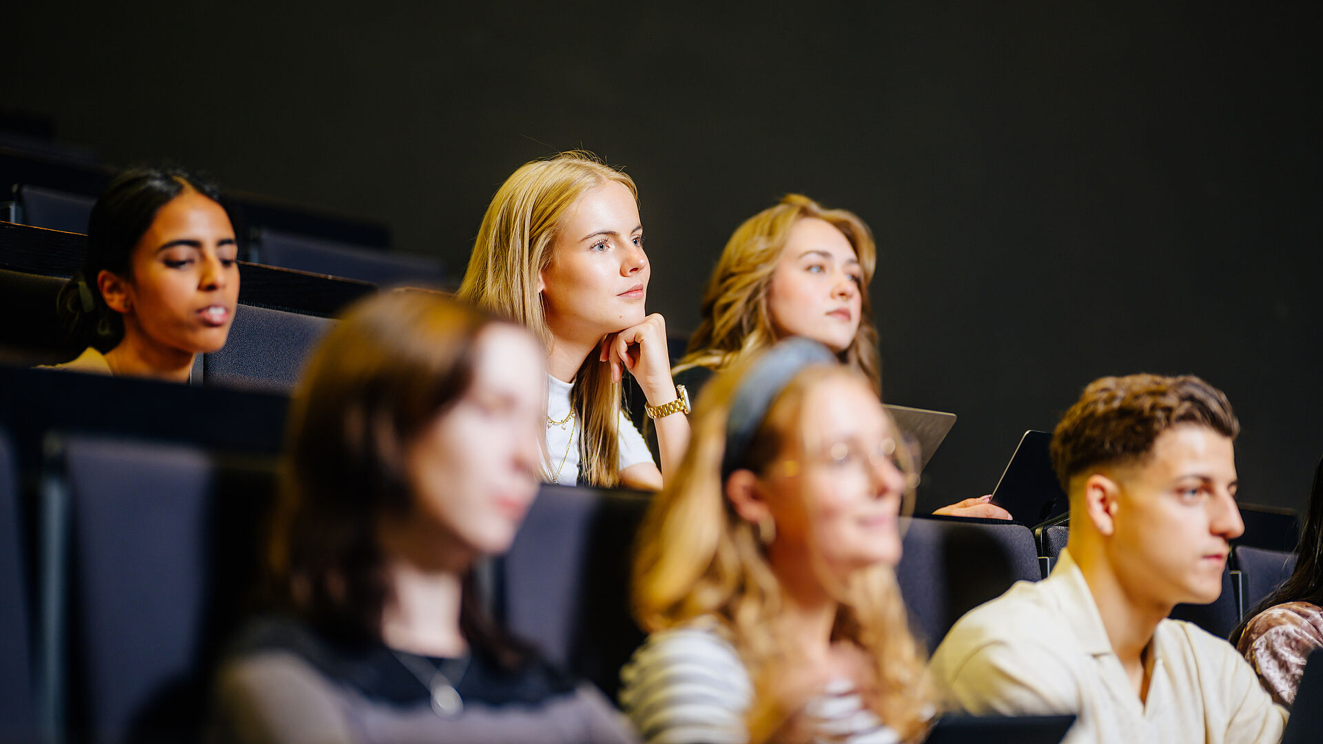 Junge Menschen sitzen zusammen in einem Hörsaal.