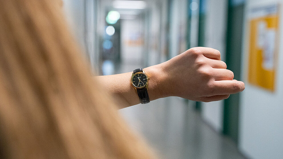 Person schaut auf die Armbanduhr.