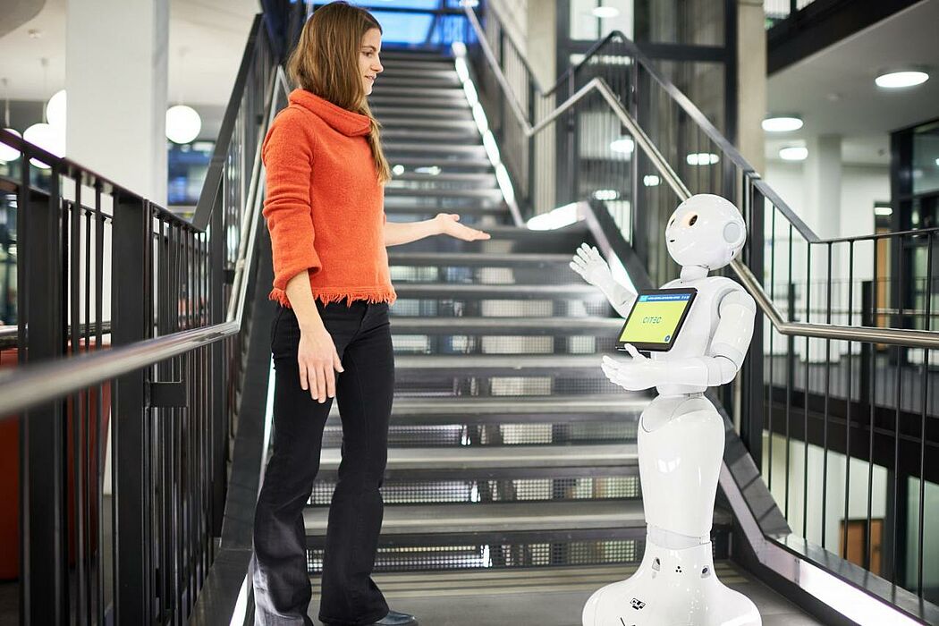 Frau spricht mit Roboter