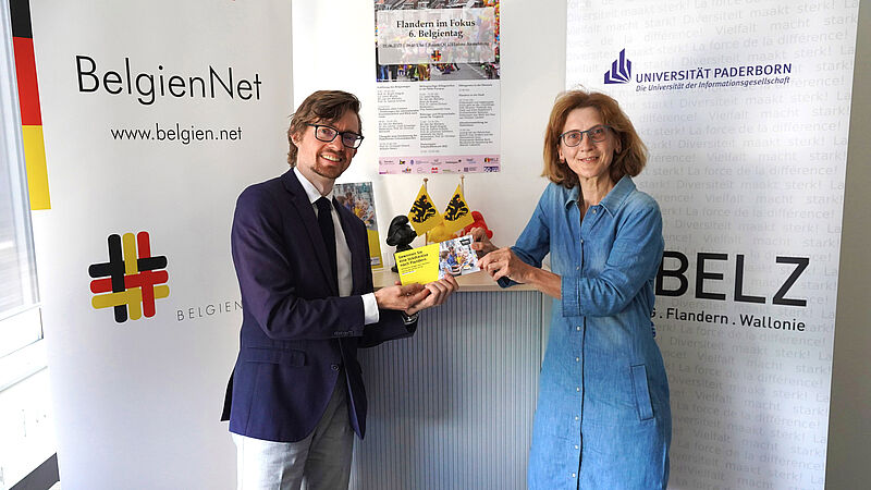 Foto (Universität Paderborn, Jennifer Strube): (v. l.) Eva Amedick erhält den Gutschein für die Reise nach Flandern von Yves Huybrechts, Mitglied des Vorstands des Belgienzentrums.