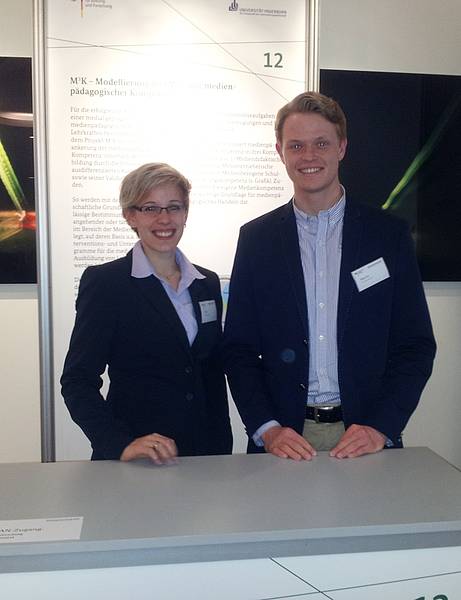 Jennifer Tiede (Ruhr-Universität Bochum) und Alexander Martin (Universität Paderborn) am Messestand des Projektes. 