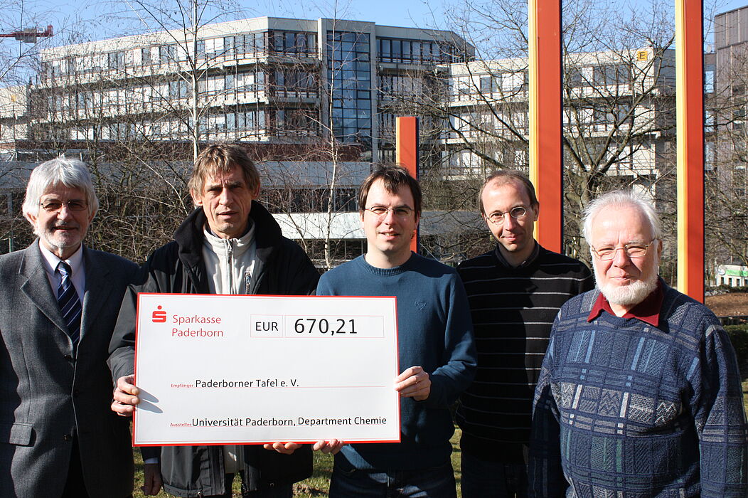 Foto (Universität Paderborn, Patrick Kleibold): Die Vertreter der Chemie freuen sich darüber, Uwe Hoffmann von der Paderborner Tafel einen Scheck in Höhe von 670,21 Euro überreichen zu können: (v.l.) Prof. Dr. Gerald Henkel, Uwe Hoffmann, Christian K