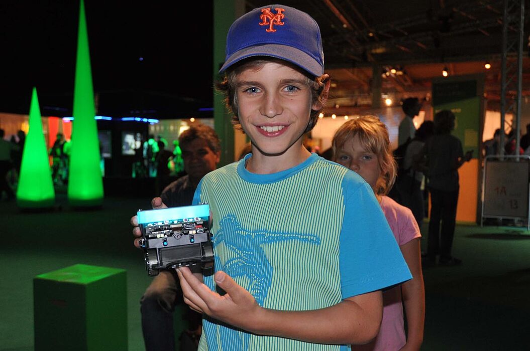 Foto: David mit dem Miniroboter BeBot: Auf dem Ideenpark konnte er den Roboter mit einem Wii-Board durch einen Parcours steuern und dabei gegen einen anderen, autonom fahrenden Roboter antreten.