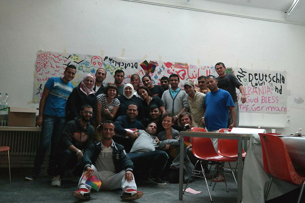 Foto (Universität Paderborn, Fach Kunst): Gruppenbild mit einigen Flüchtlingen und Helferinnen.