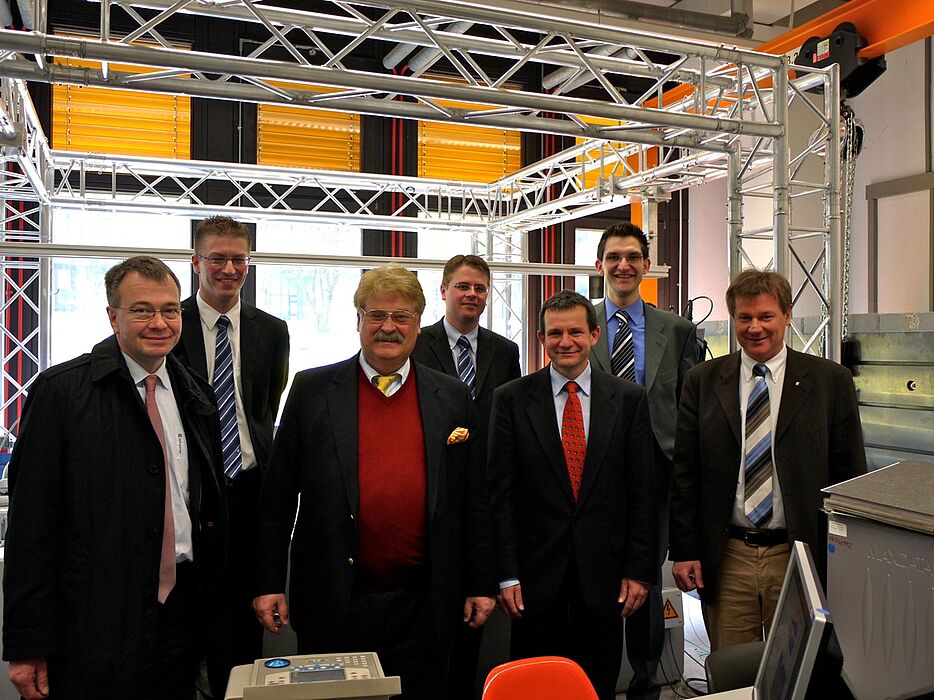 Foto (Universität Paderborn, Heike Probst): Beim Crashtest im Forschungslabor: (v. l.) vorn: Prof. Dr.-Ing. Werner Homberg, Lehrstuhl für Umformende und Spanende Fertigungstechnik (LUF), MdEU Elmar Brok, Prof. Dr. rer. nat. Thomas Tröster, Lehrstuhl f