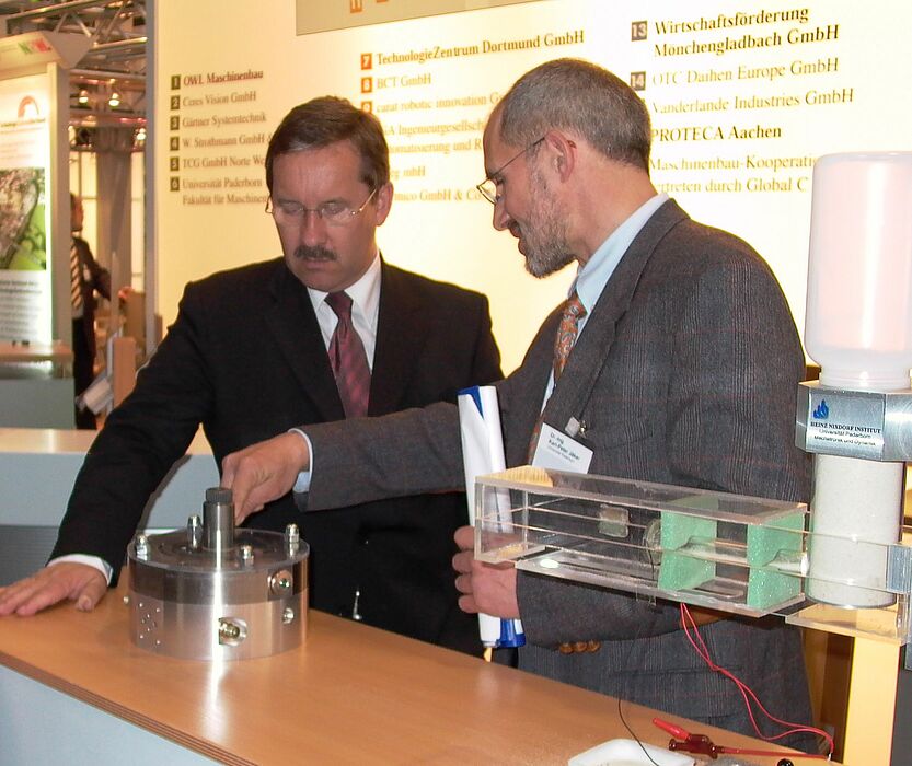 Foto: Minister Schartau (li.) lässt sich von Dr.-Ing. Karl-Peter Jäker, Universität Paderborn, das Prinzip der Flügelzellenpumpe erklären