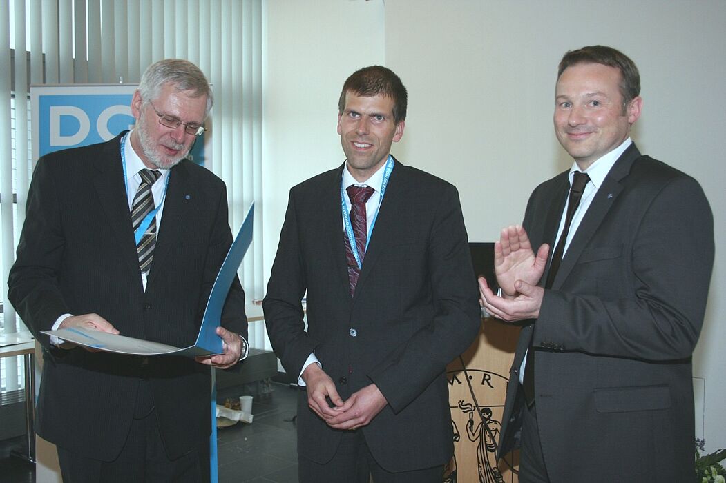 Foto (Deutsche Gesellschaft für Materialkunde DGM): Übergabe des Georg-Sachs-Preises der DGM an Dr.-Ing. Thomas Niendorf (Mitte) durch den Vorsitzenden der DGM Prof. Dr.-Ing. Hans-Jürgen Christ (links) und Prof. Dr. Alexander Hartmaier (rechts)