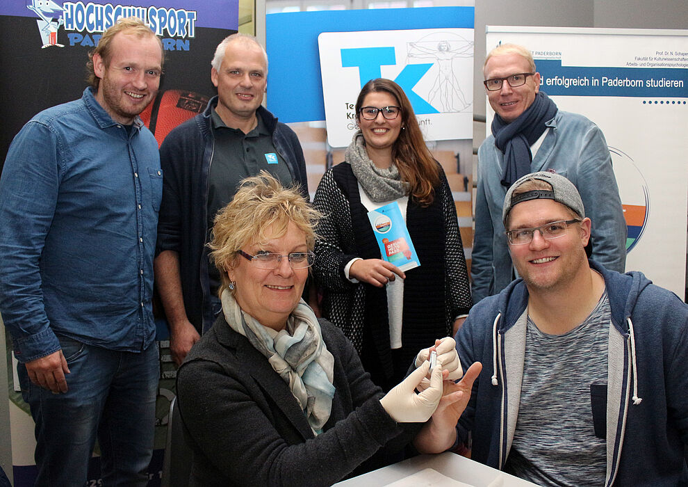 Foto (Universität Paderborn, Heiko Appelbaum): Das tat nicht weh: Arne Östlund (vorne rechts) ließ sich von Christa Richter (vorne links) screenen. An der Aktion waren beteiligt (hinten v. l.): Dennis Fergland (mein beneFIT@upb.de), Hans-Norbert Blome 