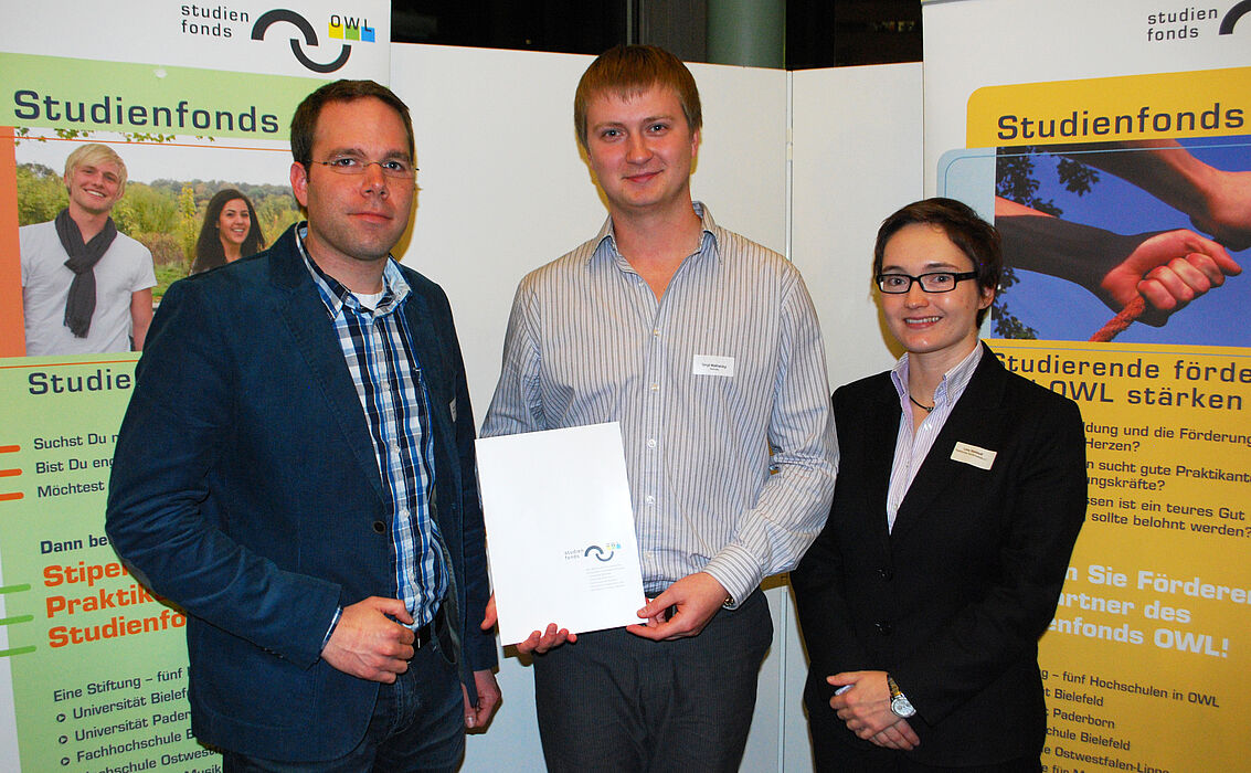 Foto (Stiftung Studienfonds OWL): v. li.: Dennis Kortebusch (Schatzmeister PHK), Stipendiat Sergii Mykhalskyi und Lena Steinhoff (Schriftführerin PHK) bei der feierlichen Stipendienvergabe im Audimax der Universität Paderborn. Nicht auf dem Foto: Stipen