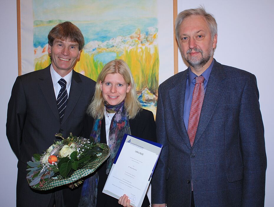 Foto (Universität Paderborn, Frauke Döll): Dr. Nina Hinrichs erhält von Präsident Prof. Dr. Nikolaus Risch und Prof. Dr. Wilhelm Schäfer, Vizepräsident für Forschung und wissenschaftlichen Nachwuchs, die Urkunde über das Stipendium.