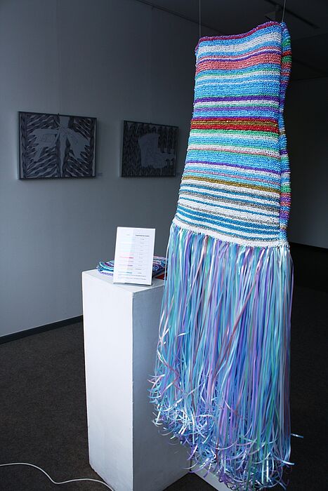 Foto (Frauke Döll): Das gestrickte Kleidobjekt von Anastasia Frühauf verschlüsselt einen Spruch mittels Farben und Reihen.