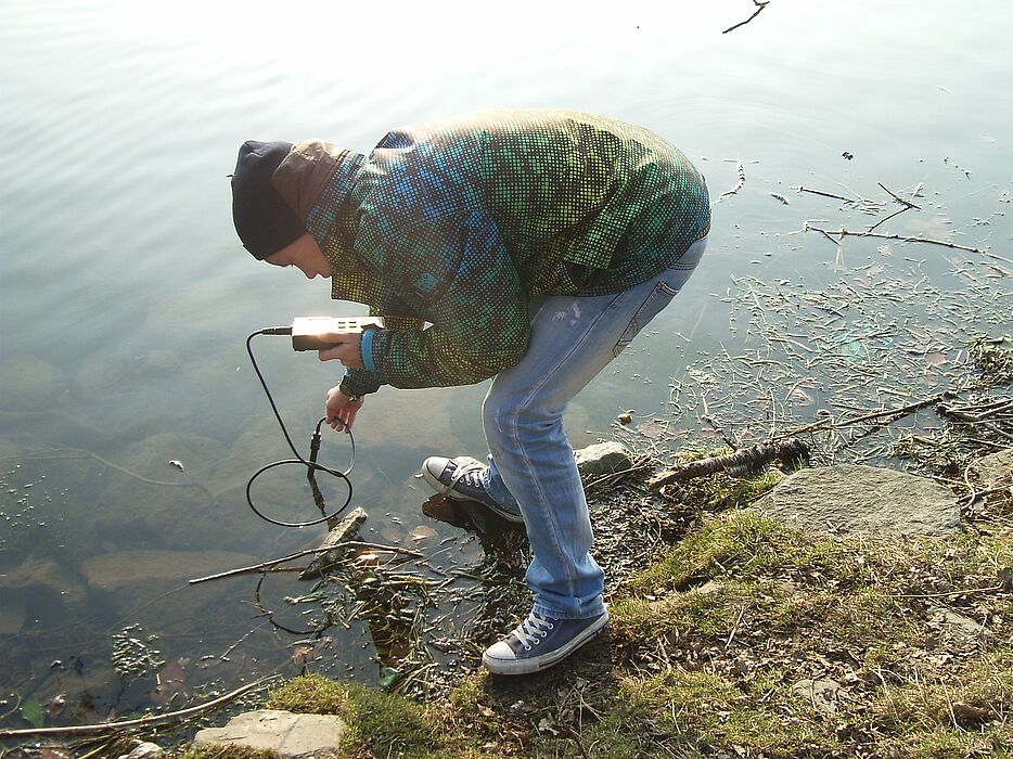 Foto (Universität Paderborn): Stephan Berg bei der Entnahme von Gewässerproben am Einlauf der Pader in den Padersee.