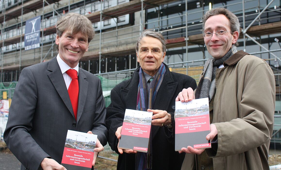 Foto (Universität Paderborn, Patrick Kleibold): Universitätspräsident Prof. Dr. Nikolaus Risch präsentiert mit den beiden Herausgebern Prof. Dr. Frank Göttmann und Dr. Thomas Reuther den Sammelband „Baustelle Informationsgesellschaft und Universit