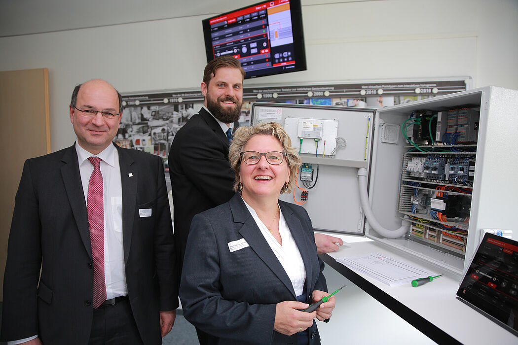Foto (Michael Adamski): Zeigen NRW-Wissenschaftsministerin Svenja Schulze eine digitale Montageanleitung für einen Schaltschrank: Prof. Ansgar Trächtler (Leiter Fraunhofer IEM, links) und Matthias Greinert (Wissenschaftler am Fraunhofer IEM).