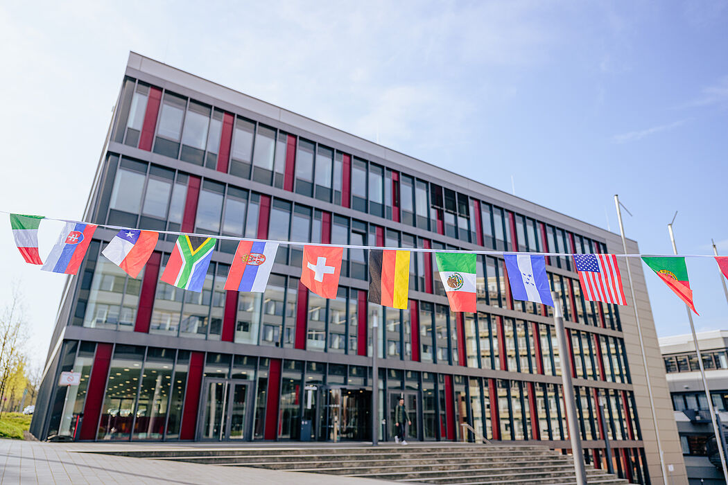 Verschiedene Länderflaggen vor einem Universitätsgebäude