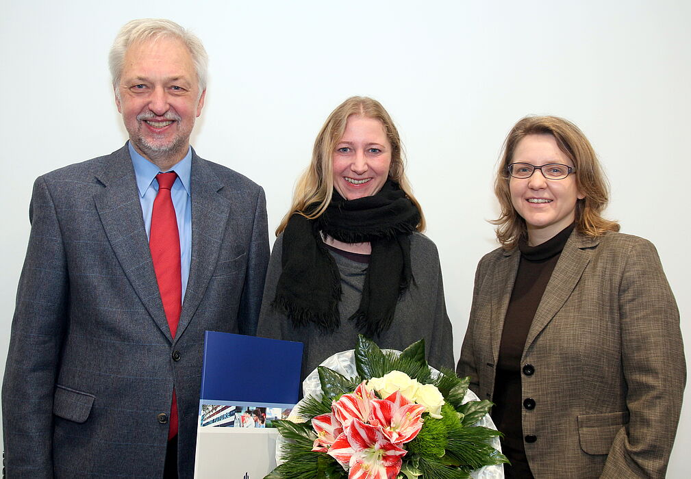 Foto (Universität Paderborn, Nina Reckendorf): Uni-Präsident Prof. Dr. Wilhelm Schäfer und Prof. Dr. Christine Silberhorn (rechts), Vizepräsidentin für Forschung und wissenschaftlichen Nachwuchs, gratulieren Dr. Charis Goer (Mitte) zu dem Stipendium.