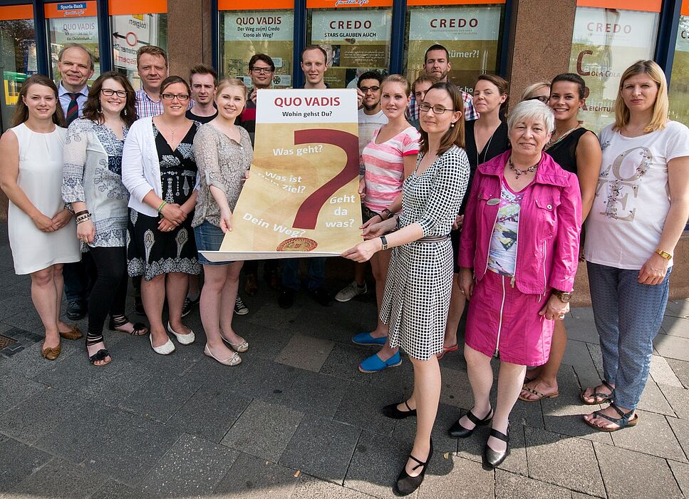 Foto (Pressebüro CREDO-Ausstellung): Studentinnen und Studenten der Universität Paderborn präsentieren ihr Begleitprojekt zur CREDO-Ausstellung zusammen mit Prof. Dr. Stiegemann, Direktor des Diözesanmuseums Paderborn (hinten links), Prof. Dr. Nicole 