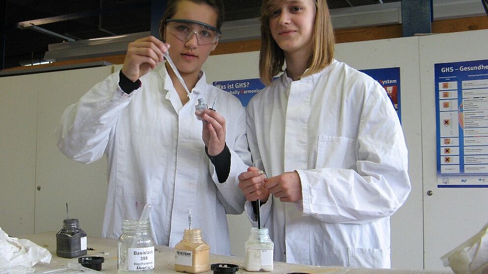 Foto (Universität Paderborn, Simone Rudolph): Zwei Schülerinnen experimentieren bei einem Lackchemie-Workshop, der in Rahmen der Summer School des vergangenen Jahres durchgeführt wurde.