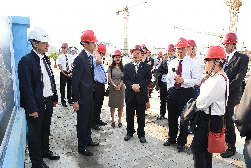 Foto (Zhiquan Lin): Besuch der Bauarbeiten auf dem CDC: Xu Haijie, Vizepräsident des Verwaltungskomitees des Sino-German Ecopark, sowie Hua Jun, Deputy Generalmanager Sino-German Dual Education Technology Co., Ltd. Berichten über CDC Baustatus.