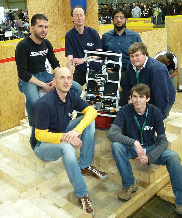 Foto (GET Lab, Dirk Fischer): Erfolgreich: Das GETbot-Team 2012, bestehend aus Muhannad Mujahed (v. l.), Timo Korthals, Dirk Fischer, Zaheer Aziz, Florian Frings und Heinrich Drobin, holte den dritten Platz bei den RoboCup German Open.