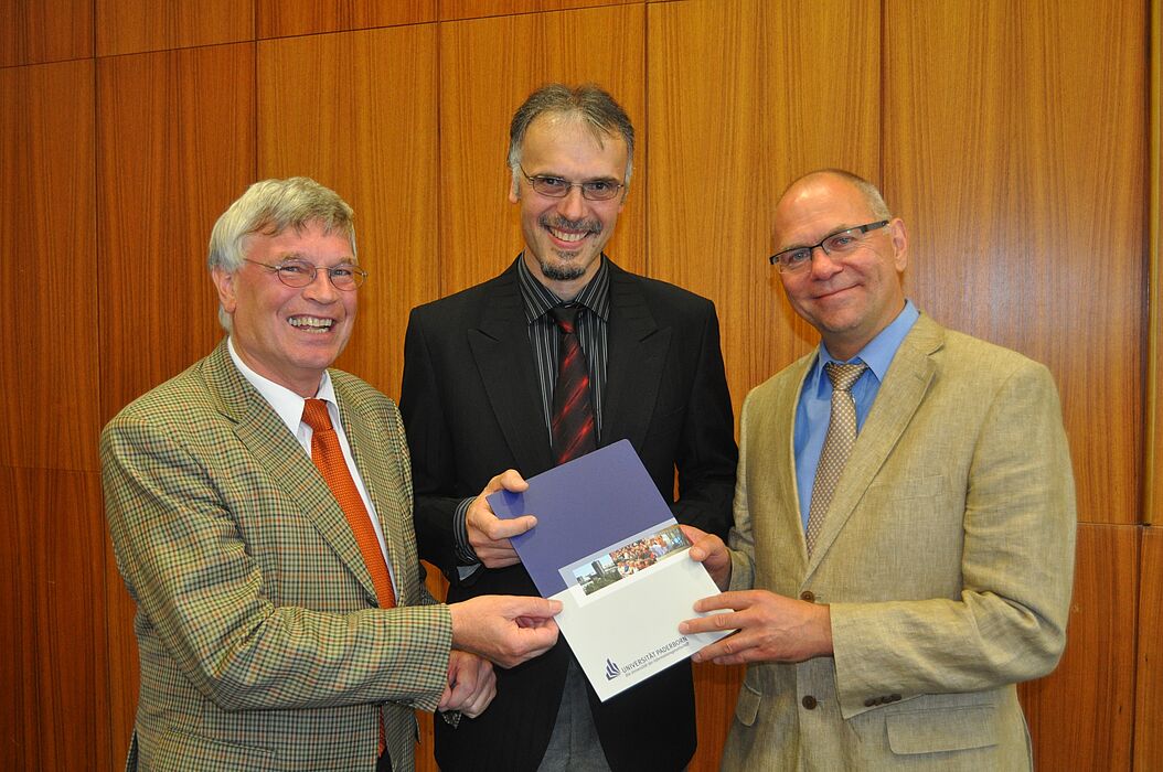 Foto (Mark Heinemann): Privatdozent Dr.-Ing. Gunter Kullmer (Mitte) erhält die Professorenurkunde aus den Händen des Dekans der Fakultät für Maschinenbau, Prof. Dr.-Ing. Detmar Zimmer (rechts), und Prof. Dr.-Ing. Hans Albert Richard (links).
