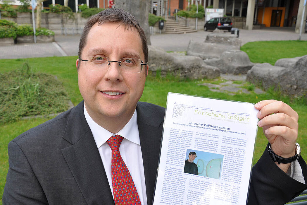 Foto (Nadija Pejic, Institut für Informatik): Prof. Dr. Marco Platzner mit der ersten Ausgabe von „Forschung inSight“.