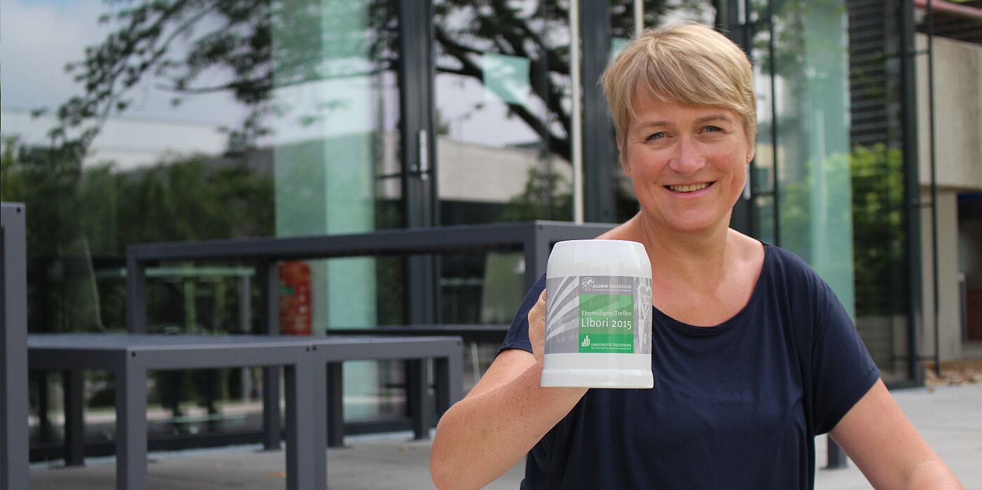Foto: (Universität Paderborn, Julia Pieper) Ein Krug extra für Libori: Alexandra Dickhoff von Alumni Paderborn lädt ein zum Ehemaligen-Treff am Libori-Freitag. Die ersten 50 Besucher erhalten den aktuellen Alumni-Krug.