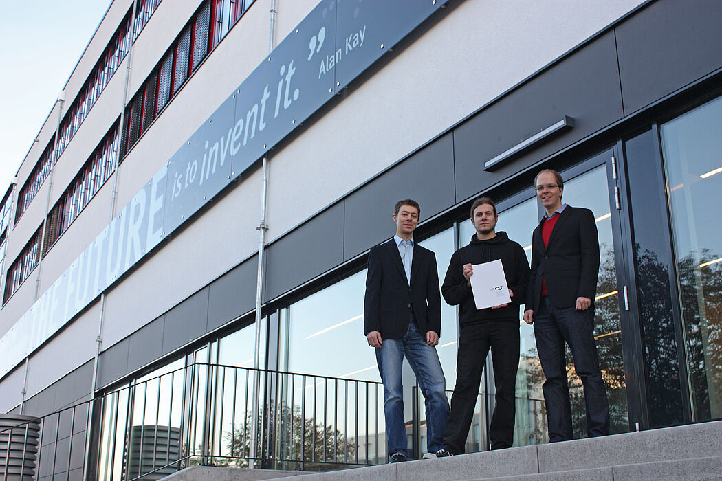 Foto (Universität Paderborn, Jan Aulenberg): Malte Splietker (Mitte) wird zu seinem Stipendium von Jannis Weide und Andreas Cord-Landwehr aus dem Vorstand des Ehemaligenvereins „Die Matiker e. V.“ beglückwünscht.