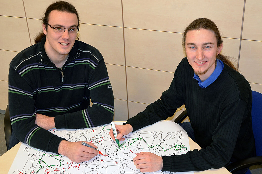 Foto (Universität Paderborn, Jana Neuhaus): Graphabstraktion anschaulich: Dominik Steenken und Steffen Ziegert (rechts) bei Planung und Fehlervermeidung.
