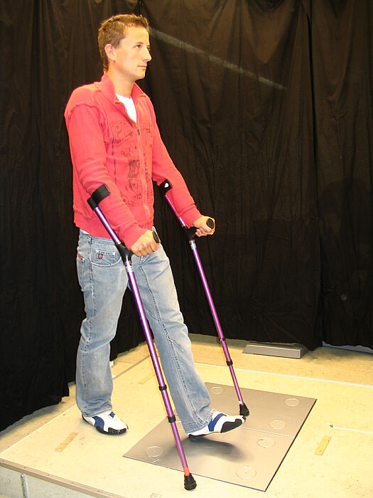 Foto: Versuchsperson beim biomechanischen Feedbacktraining. Die dynamometrischen Plattformen dienen zur Messung der Teilbelastung.