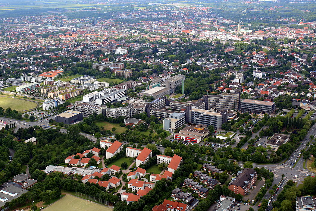 Foto (Universität Paderborn, Patrick Kleibold): Luftbild der Uni vom 14. Juni 2013. Im Hintergrund die Stadt und der Paderborner Dom.