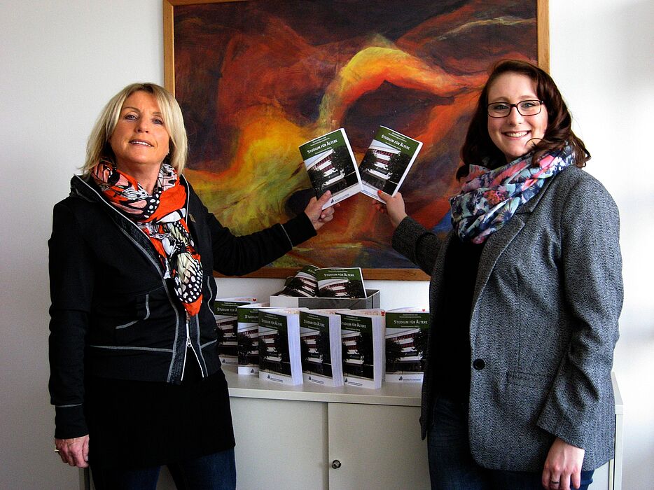 Foto (Universität Paderborn, Cornelia Filter): Birgitt Lammert (links), externe Koordinatorin des Studiums für Ältere, und Katharina Braun, studentische Hilfskraft im Sekretariat, mit den druckfrischen Studienführern.