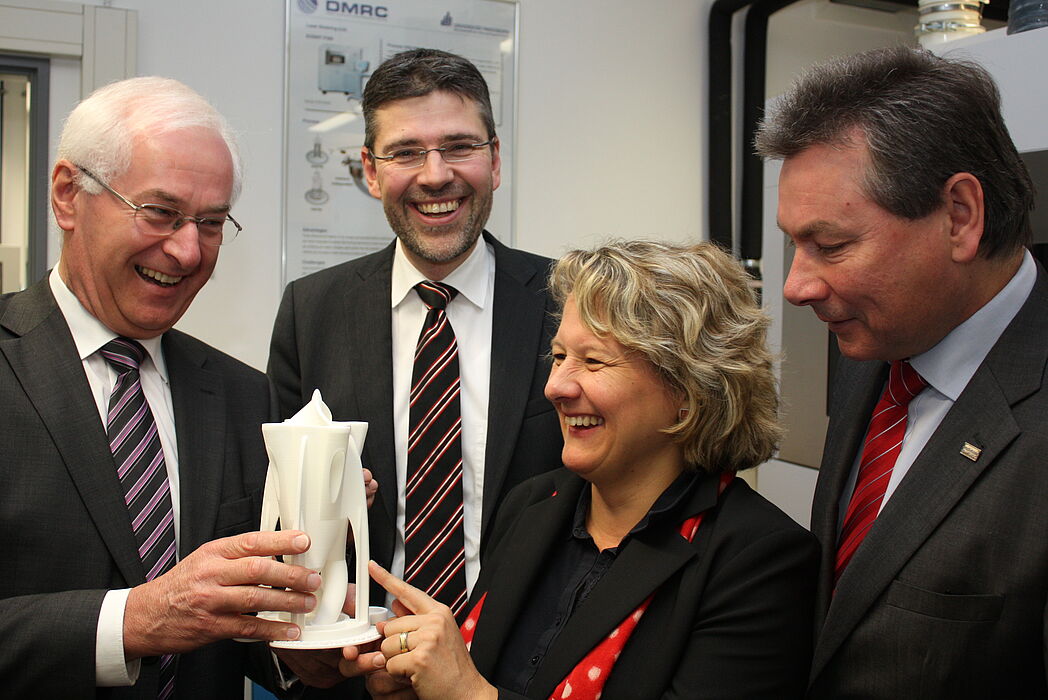 Foto (Universität Paderborn, Patrick Kleibold): Prof. Dr.-Ing. Hans-Joachim Schmid (hinten) präsentiert der NRW-Wissenschaftsministerin Svenja Schulze, dem stellvertretenden Landrat des Kreises Paderborn, Bernhard Wissing (l.), und dem stellvertretenden