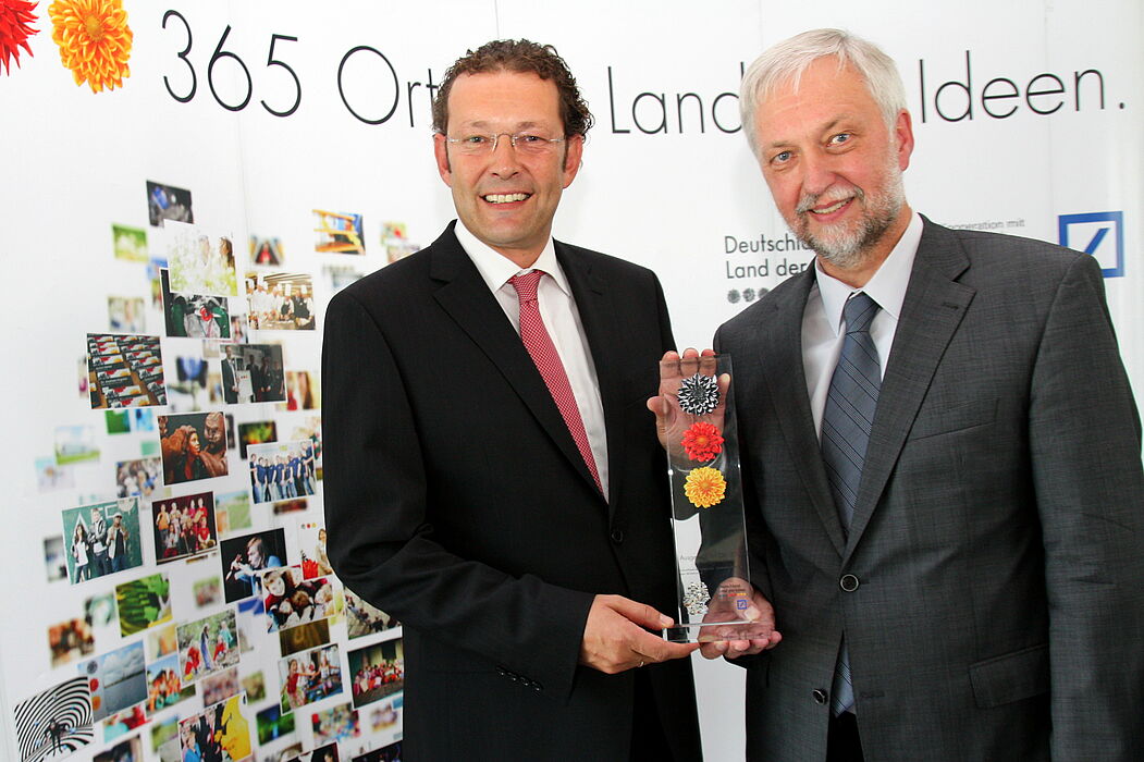 Foto (Universität Paderborn, Patrick Kleibold): Dietmar Kellerhoff (links) von der Deutschen Bank überreicht Prof. Dr. Wilhelm Schäfer, Geschäftsführer der Projektentwicklungsgesellschaft Zukunftsmeile Fürstenallee und Vizepräsident der Universitä