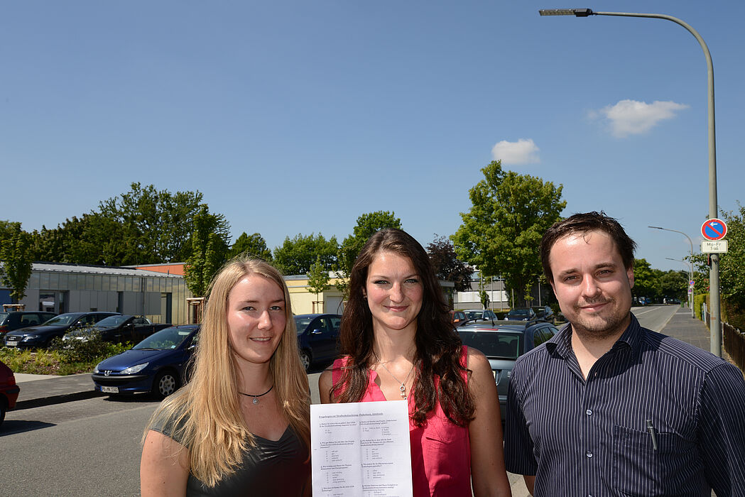 Foto (v. l.): Die beiden Studentinnen Lena Zingraff und Anastasia Völker mit dem Fragenbogen und Dr. Andreas Bielawny von der brandenburg gmbh in der Goerdelerstraße, deren Lampen bereits mit der LED-Technik ausgestattet sind.