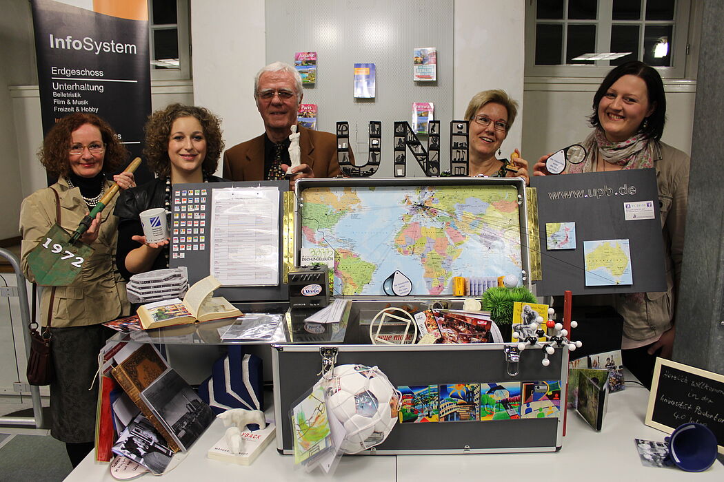 Foto (Universität Paderborn, Heiko Appelbaum): Präsentieren einen der Uni-Museumskoffer (v. l.): Prof. Dr. Jutta Ströter-Bender, Sabrina Zimmermann, Prof. Dr. Steffen Gronemeyer, Gisela Grumpe-Aßmann (Stadtbibliothek Paderborn) und Corinna Pott.