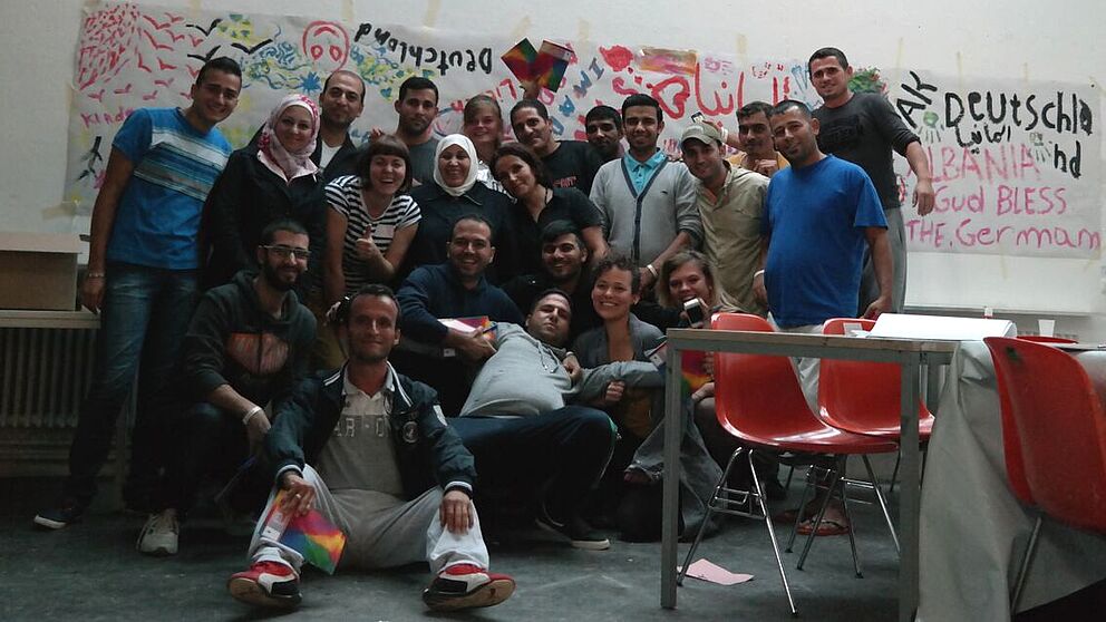 Foto (Universität Paderborn, Fach Kunst): Gruppenbild mit einigen Flüchtlingen und Helferinnen.