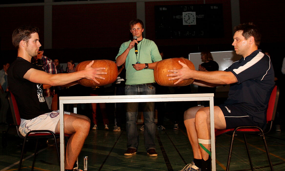 Foto (Universität Paderborn, Patrick Kleibold): Wer kann einen Medizinball mit ausgestreckten Armen länger halten? Uli Kussin und Martin Busch lieferten ein packendes Duell.