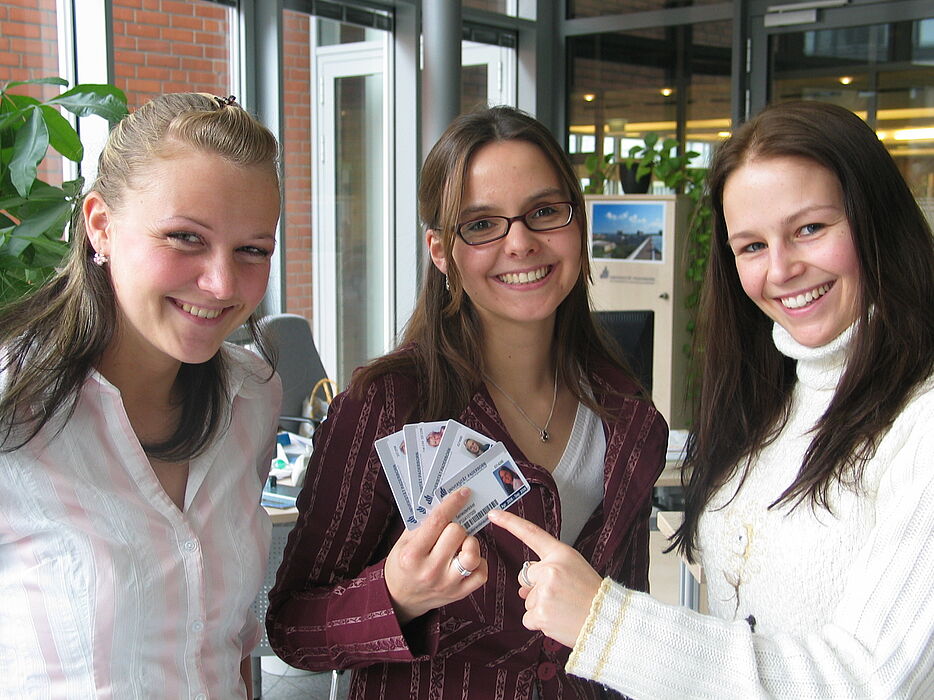 Foto (Ramona Wiesner): Freuen sich über die erweiterten Einsatzmöglichkeiten des neuen Studierendenausweises der Universität Paderborn (v. l.): Kristina Root (Service Center), Mareike Blum und Petra Matic, IBS-Studentinnen.
