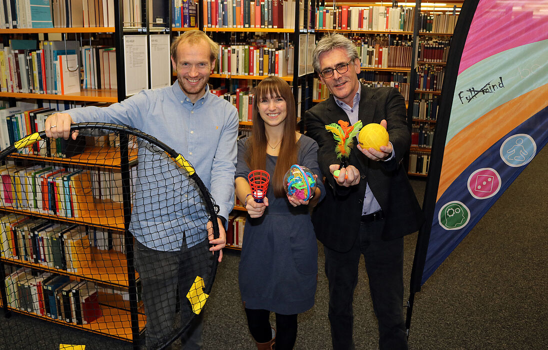 Foto (Heiko Appelbaum): Dennis Fergland, Cornelia Raetze und Dr. Dietmar Haubfleisch (v. l.) werben für bewegte Pausen in der Universitätsbibliothek Paderborn.