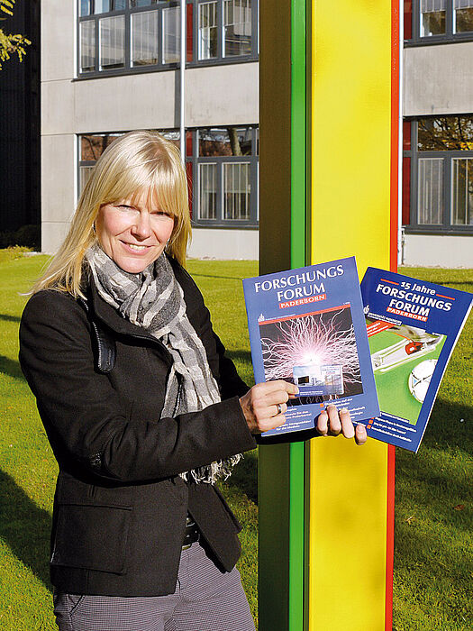 Foto (Universität Paderborn, Heike Probst): Ramona Wiesner, Leiterin des Referats Hochschulmarketing und Universitätszeitschrift, präsentiert die erste Ausgabe des ForschungsForums aus dem Jahr 1998, die Ausgabe zum 40jährigen Uni-Jubiläum sowie den 