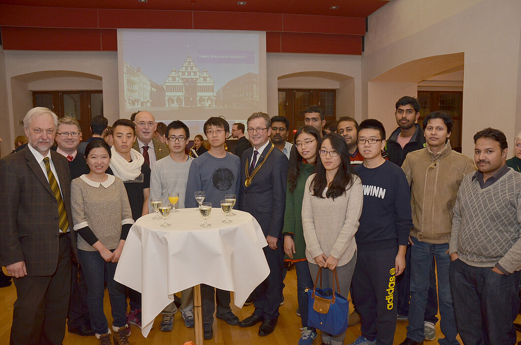 Foto (Stadt Paderborn): Die ausländischen Studierenden im Paderborner Rathaus begrüßten Bürgermeister Michael Dreier (Mitte) und Uni-Vizepräsident Wilhelm Schäfer (links).