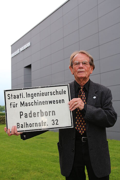 Foto (Universität Paderborn, Vanessa Dreibrodt): Ein Stück Uni-Geschichte: Prof. Dr. Lothar Weeser-Krell schenkt das alte Schild der Staatlichen Ingenieursschule für Maschinenwesen dem Universitätsarchiv.