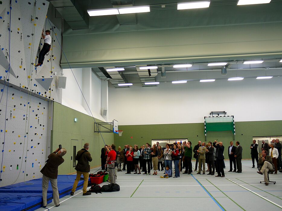 Foto (Heike Probst): Präsident Prof. Dr. Nikolaus Risch testete erfolgreich die neue Kletterwand unter den Augen der begeisterten Gäste.